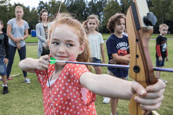 Young girl learning archery skills