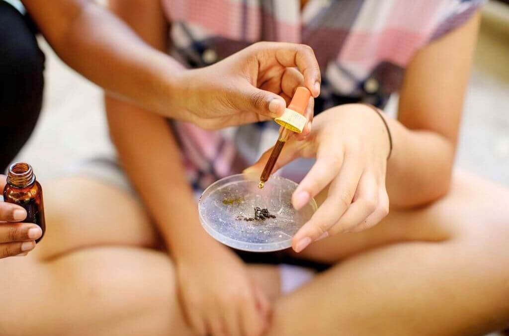 Images of students holding a petri dish and dropper