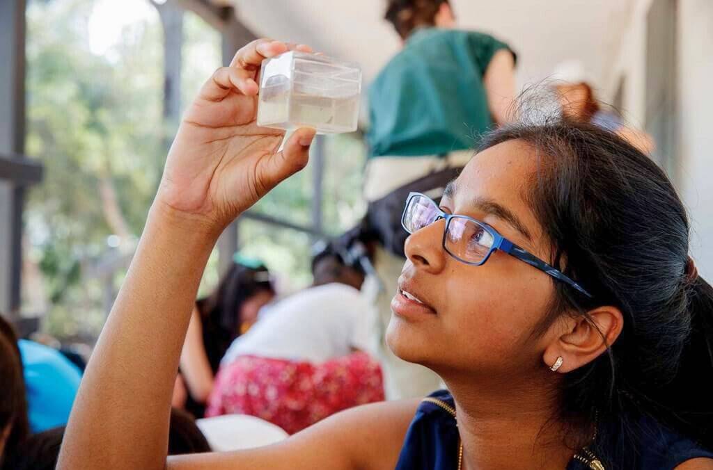 Student looking at a sample of water