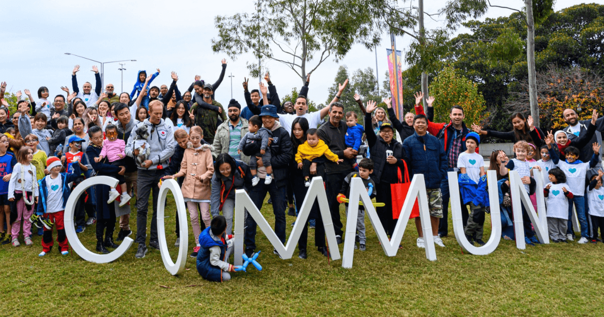 Sydney Olympic Park community members at Jacaranda Square lawn with giant letters spelling 'community'
